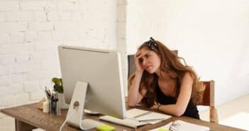 a woman sitting at a desk with a computer