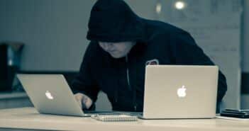 man in black hoodie using macbook