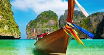 Bateau en bois dans une baie paradisiaque en thailande