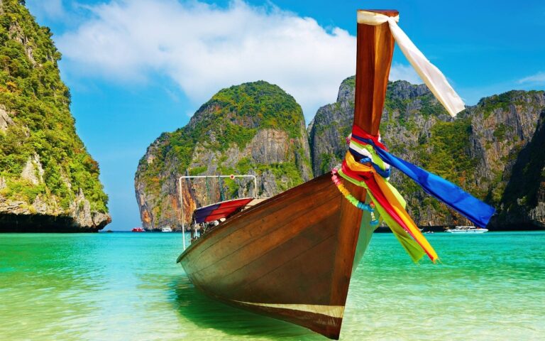 Bateau en bois dans une baie paradisiaque en thailande