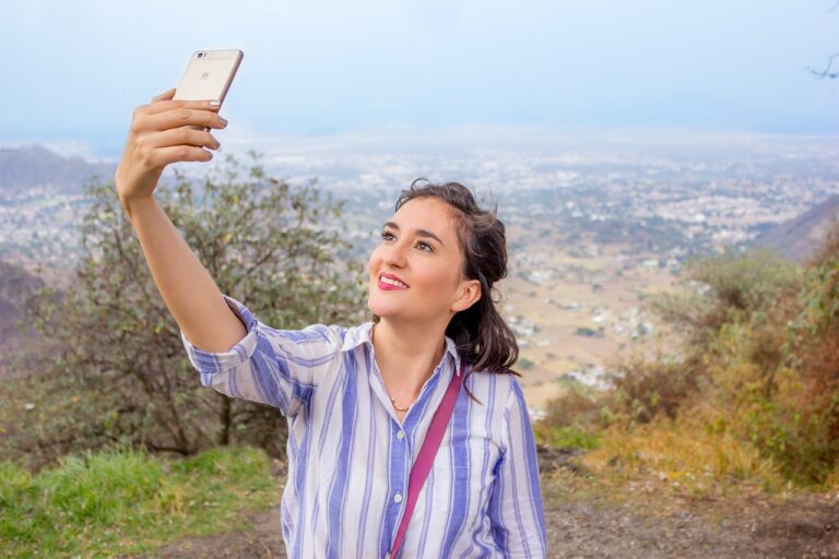 Femme tenant un smartphone dans sa main et prenant un selfie