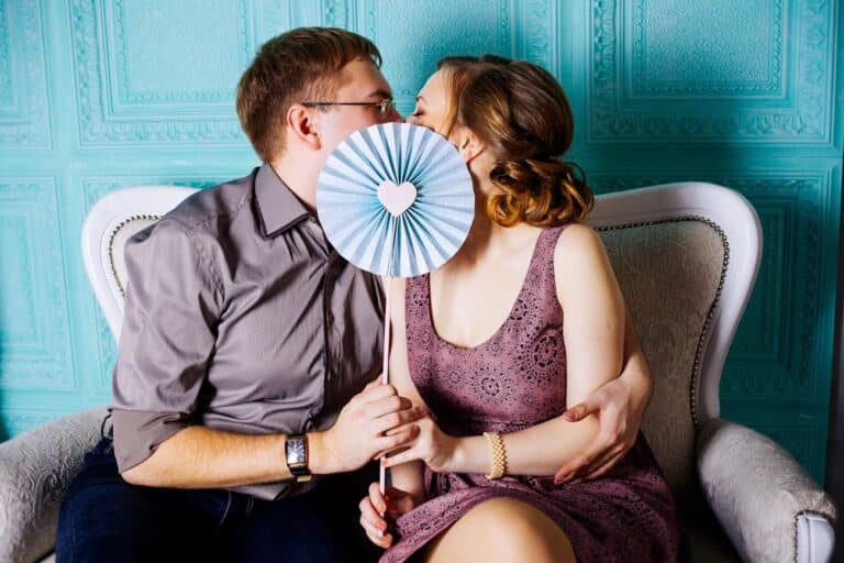 Woman and Man Sitting on Grey Suede Loveseat