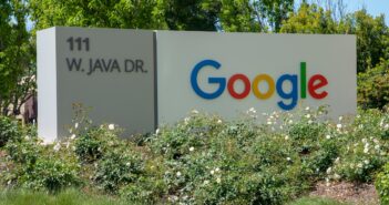 a google sign in front of some bushes and trees