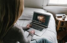 woman using gray laptop on bed