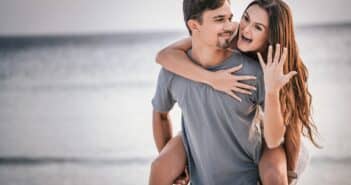 man in white crew neck t-shirt hugging woman in blue denim shorts