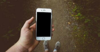 person holding silver iPhone 6 with black case