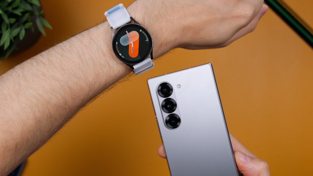 A person holding a smart watch on their wrist