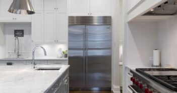 Stainless Steel Refrigerator Beside White Kitchen Cabinet