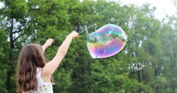 girl making bubbles during daytime