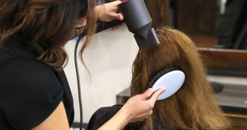 woman holding white and black hair blower