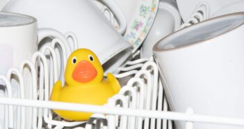 a yellow rubber duck sitting in a dishwasher