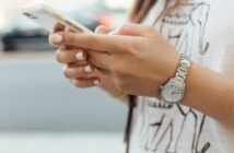 woman holding iPhone during daytime