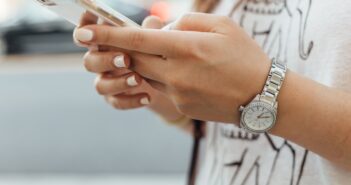 woman holding iPhone during daytime