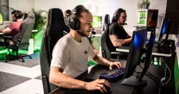 A man sitting at a computer with headphones on