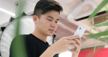 man in black crew neck t-shirt holding silver iphone 6