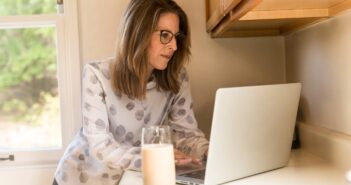 woman using her MacBook Pro inside white room