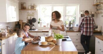 Family At Home Eating Breakfast In Kitchen Together