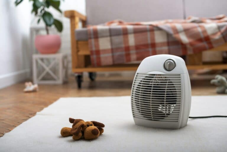 Fan heater on the floor in living room with sofa at background