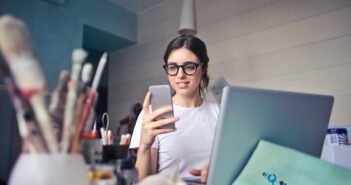 woman in white shirt using smartphone