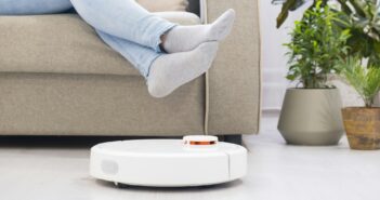 girl resting at home on the couch, while the robot vacuum cleaner. Time for yourself. smart House.