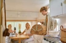 Happy family on kitchen in trailer, summer camping