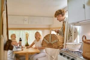 Happy family on kitchen in trailer, summer camping