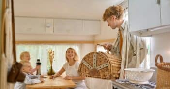 Happy family on kitchen in trailer, summer camping