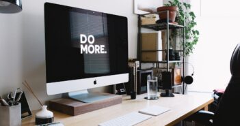 silver iMac with keyboard and trackpad inside room