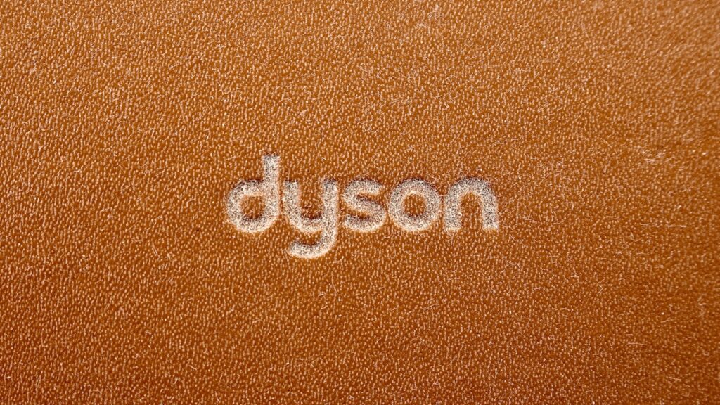 the word dyson written on a brown leather surface