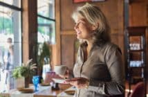 Mature beautiful woman in restaurant with cup of coffee