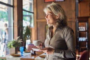 Mature beautiful woman in restaurant with cup of coffee