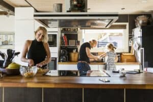 Parents preparing food with daughter (2-3) in kitchen