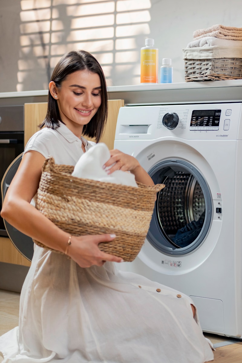 a woman is holding a basket near a washing machine