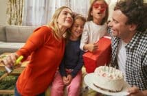 Smiling family having birthday party with cake