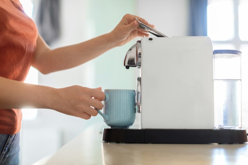 Unrecognizable Woman Preparing Morning Coffee With Modern Machine In Kitchen