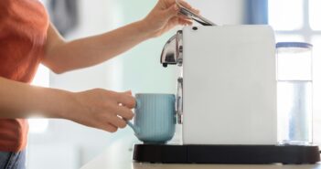 Unrecognizable Woman Preparing Morning Coffee With Modern Machine In Kitchen