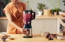 Young housewife with electric blender preparing smoothie