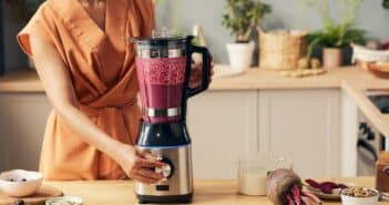 Young housewife with electric blender preparing smoothie