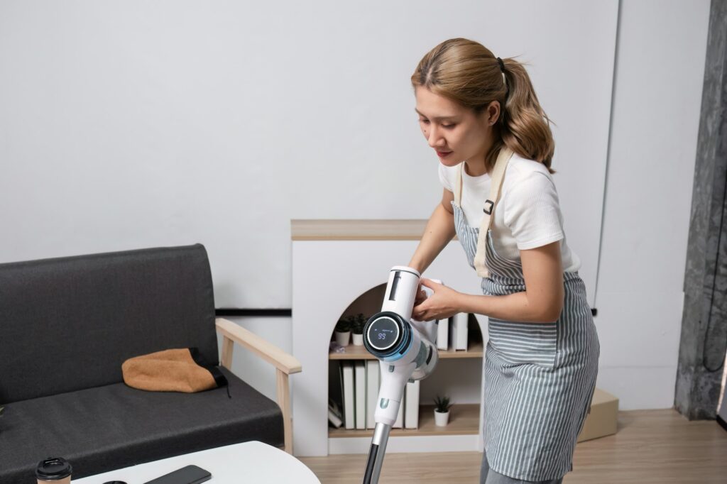 Young Woman Cleaning Modern Living Room with Vacuum Cleaner, Housekeeping and Home Maintenance