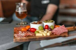 A delicious spread of cheese and charcuterie, chutney and pickles, grape and tomatoes