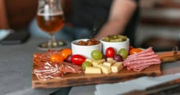 A delicious spread of cheese and charcuterie, chutney and pickles, grape and tomatoes