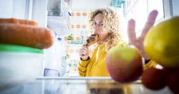 Alternaive inside view of Beautiful hungry adult woman from fridge