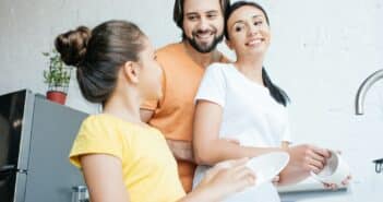 beautiful young family washing dishes together at kitchen