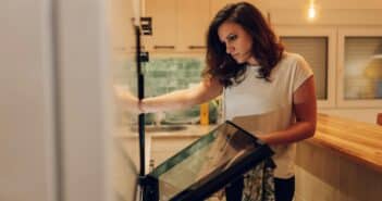 Hispanic woman looking inside the kitchen oven