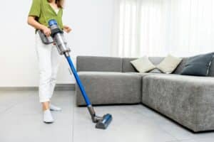 Woman cleaning floor with cordless vacuum cleaner