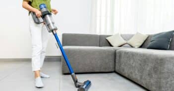 Woman cleaning floor with cordless vacuum cleaner