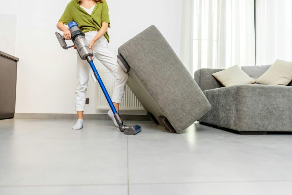 Woman cleaning floor with cordless vacuum cleaner