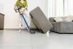 Woman cleaning floor with cordless vacuum cleaner