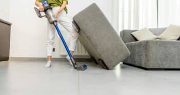 Woman cleaning floor with cordless vacuum cleaner