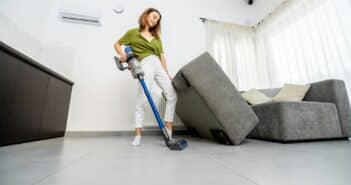 Woman cleaning floor with cordless vacuum cleaner